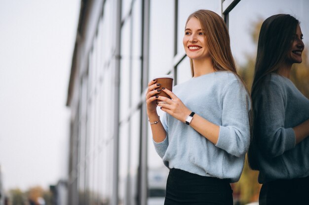 Young woman drinking coffee by the cafe