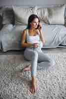 Free photo young woman drinking coffee at home