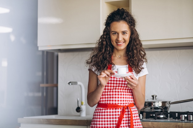 Young woman drinking coffee at the kitchen in the morning