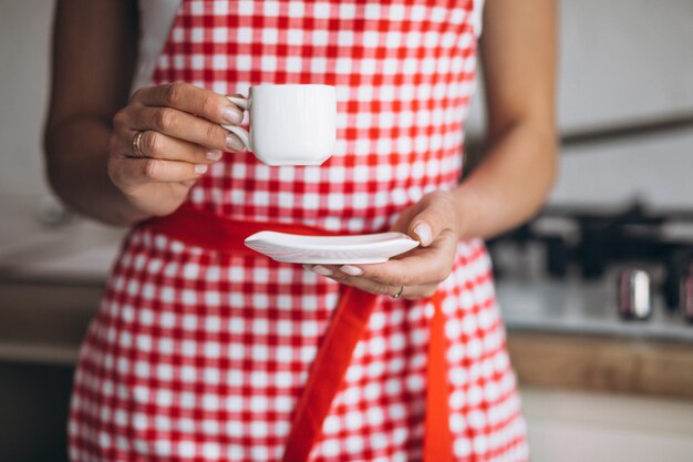 朝のキッチンでコーヒーを飲む若い女性