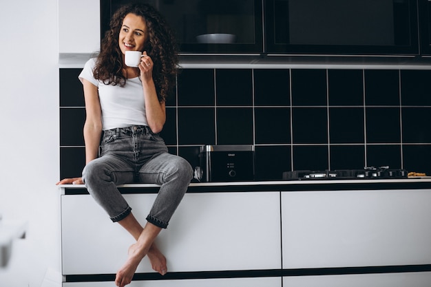 Young woman drinking coffee at the kitchen