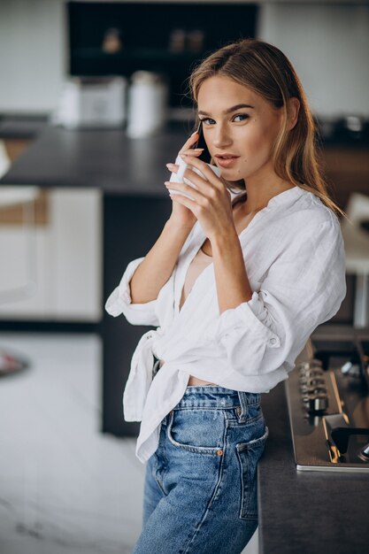 キッチンでコーヒーを飲む若い女性