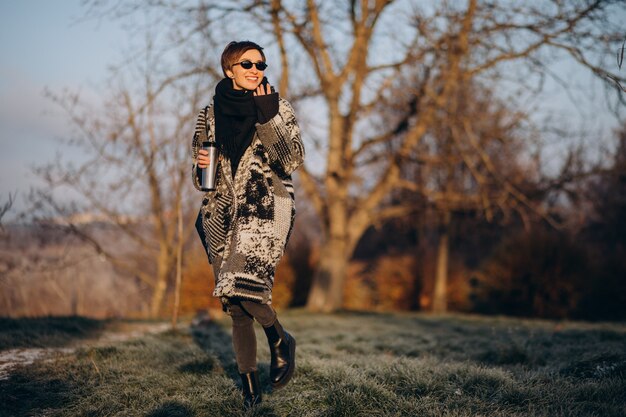 Young woman drinking coffee in the morning and walking in park