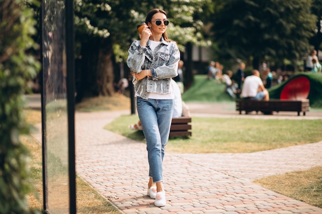 Young woman drinking coffee in park