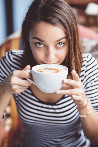 도시 카페에서 커피를 마시는 젊은 여자