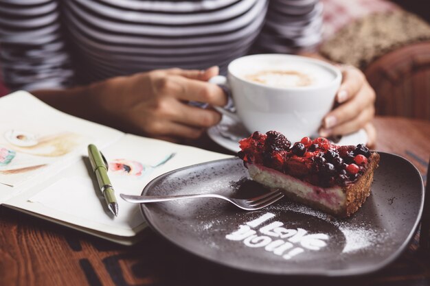 Young woman drinking coffee in urban cafe