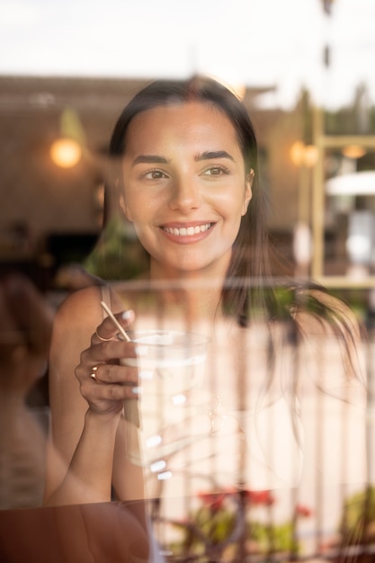 Free photo young woman drinking iced coffee