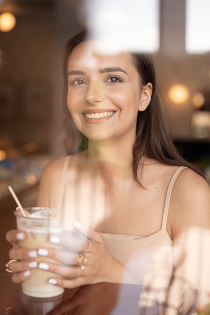 Free photo young woman drinking iced coffee