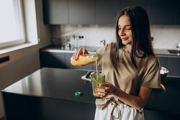 Young woman drinking juice at home