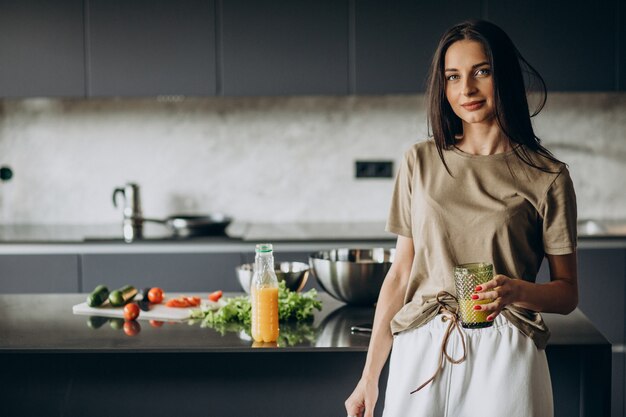 Young woman drinking juice at home