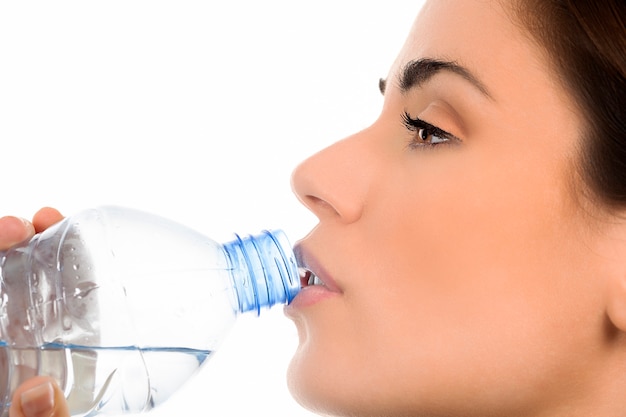 Giovane donna di bere acqua minerale in bottiglia,