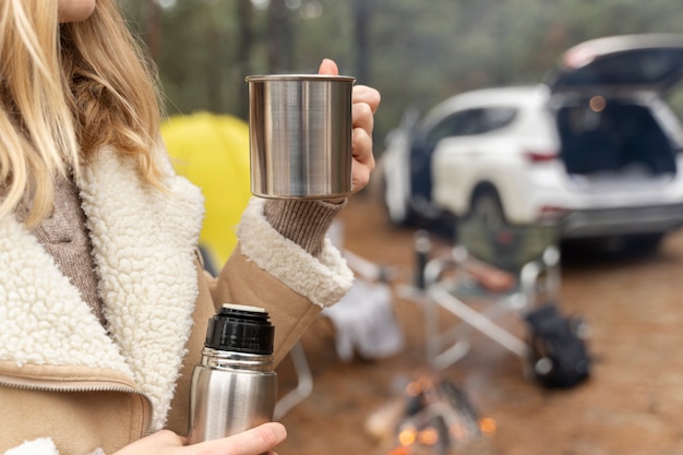 Young woman drinking water while camping