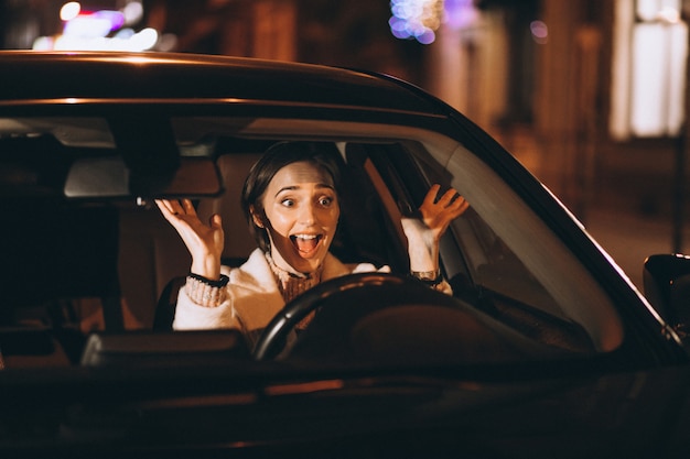 Young Woman Driving In Car At Night