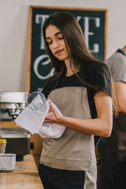 Free photo young woman drying glass