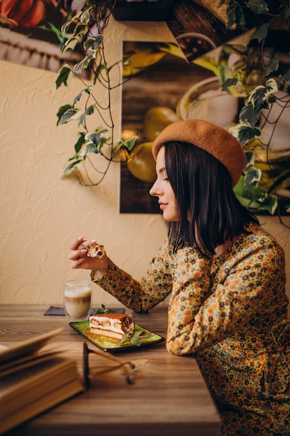 Young woman eating delicious tiramisu in a cafe