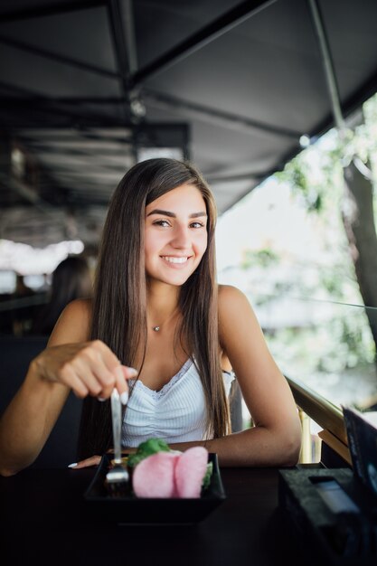 Young woman eating healthy meal sitting in the beautiful interior