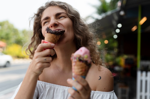 Foto gratuita giovane donna che mangia il cono gelato