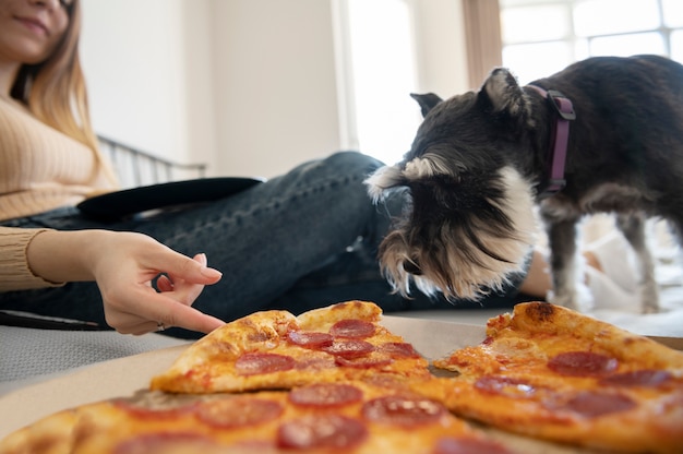 ベッドでピザを食べる若い女性