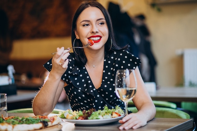 Young woman eating salad in a cafe