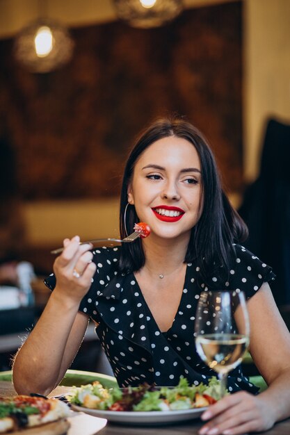 Young woman eating salad in a cafe