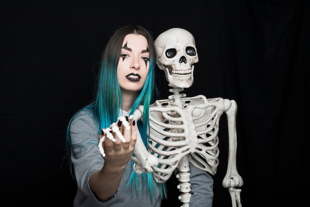 Young woman embracing skeleton