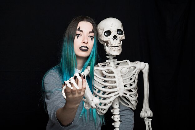 Young woman embracing skeleton