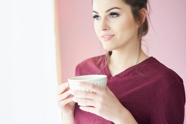 Giovane donna che si gode una tazza di caffè al mattino