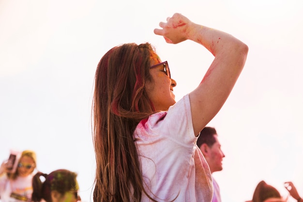 Giovane donna godendo e ballando in holi con i colori