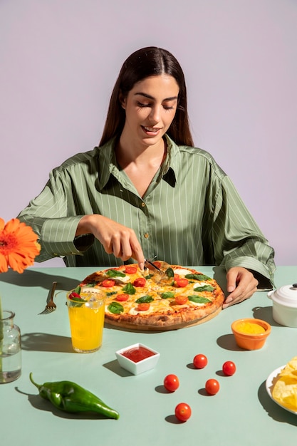 Молодая женщина, наслаждаясь вкусной пиццей