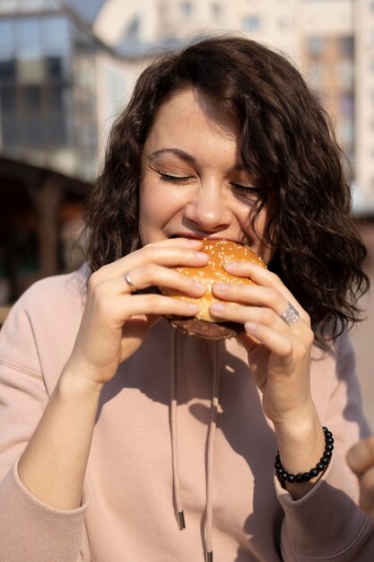 Молодая женщина, наслаждаясь уличной едой на открытом воздухе