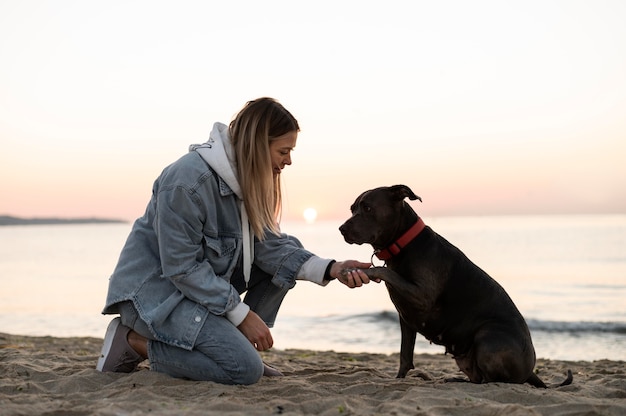 무료 사진 그녀의 강아지와 함께 시간을 즐기는 젊은 여자