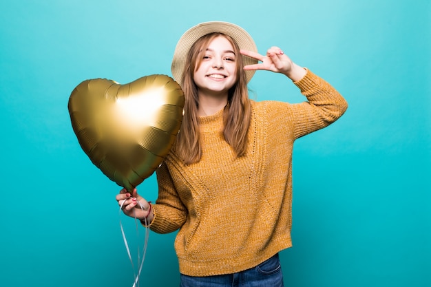 Young woman enjoys festive occasion holding metallic balloon