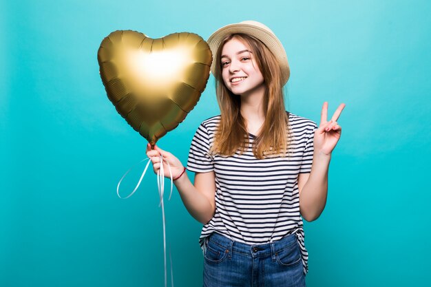 Young woman enjoys festive occasion holding metallic balloon