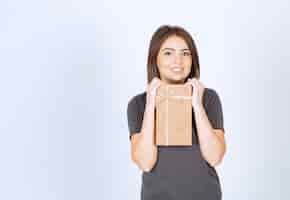 Бесплатное фото Молодая женщина взволнована подарочной коробкой.