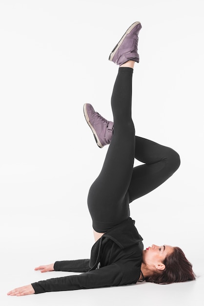 Young woman exercising against white background