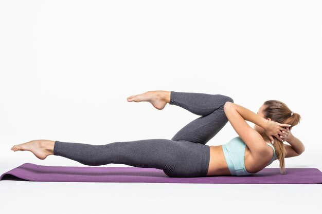 Young woman exercising and doing a crunch to work her abs isolated