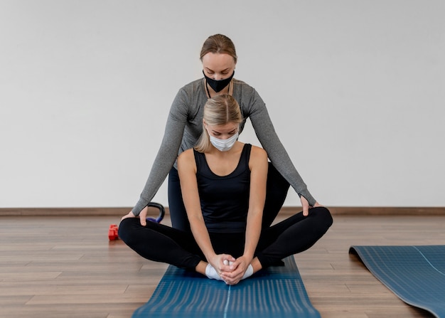 Foto gratuita giovane donna che si esercita in palestra indossando maschere mediche