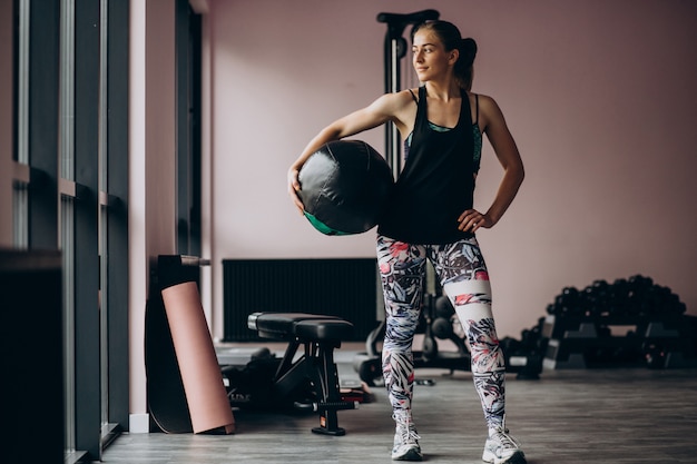 Foto gratuita giovane donna che si esercita in palestra con peso