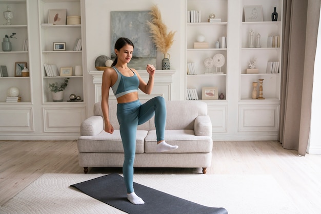 Young woman exercising at home alone