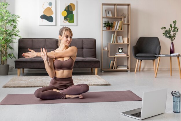 Young woman exercising at home on mat