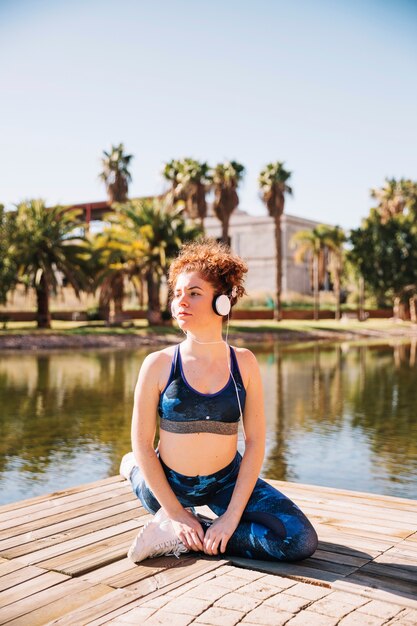 Young woman exercising near water