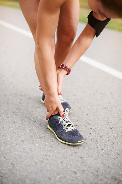 屋外で運動する若い女性。足首がねじれているのが怖い