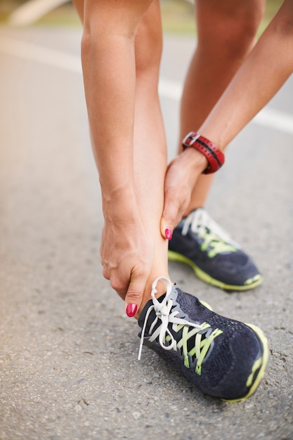 Young woman exercising outdoor. Injury can happen to you anytime