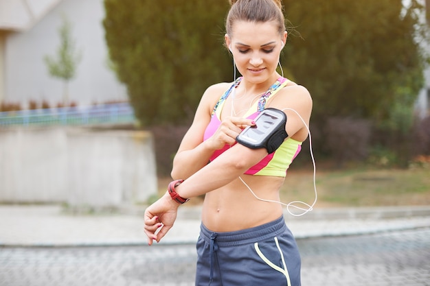 Giovane donna che si esercita all'aperto. la mia musica preferita mi aiuta a fare sport