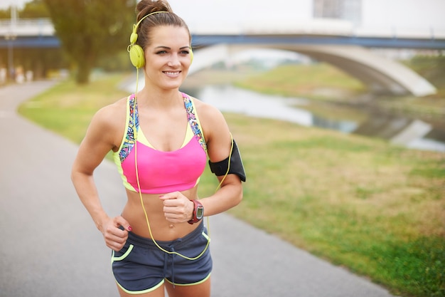 Young woman exercising outdoor. Park is my favorite place to go jogging