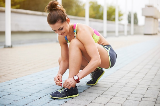 屋外で運動する若い女性。運動前の準備は非常に重要です