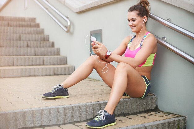 Young woman exercising outdoor. Short text message and I am back to jogging