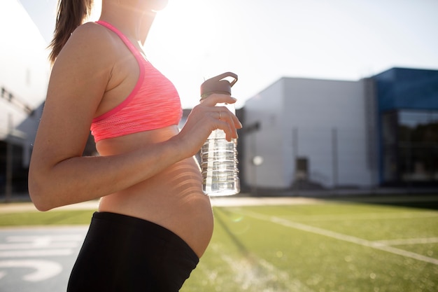 Young woman exercising during pregnancy with copy space