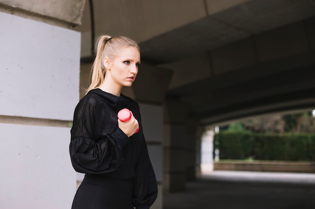 Free photo young woman exercising with dumbbell