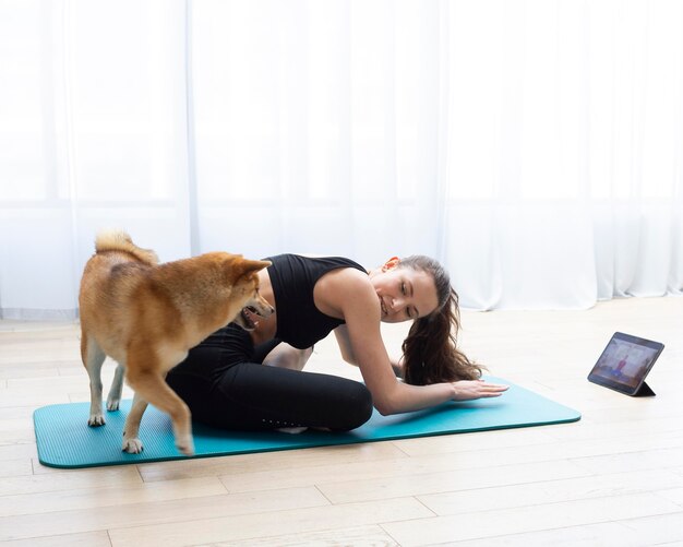 犬と一緒に運動する若い女性